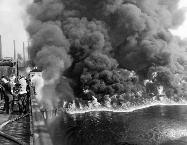 The Cuyahoga River burns in 1952 near Cleveland, Ohio in the United States as an oil slick is ignited. Special Collections, Cleveland State University Library.
